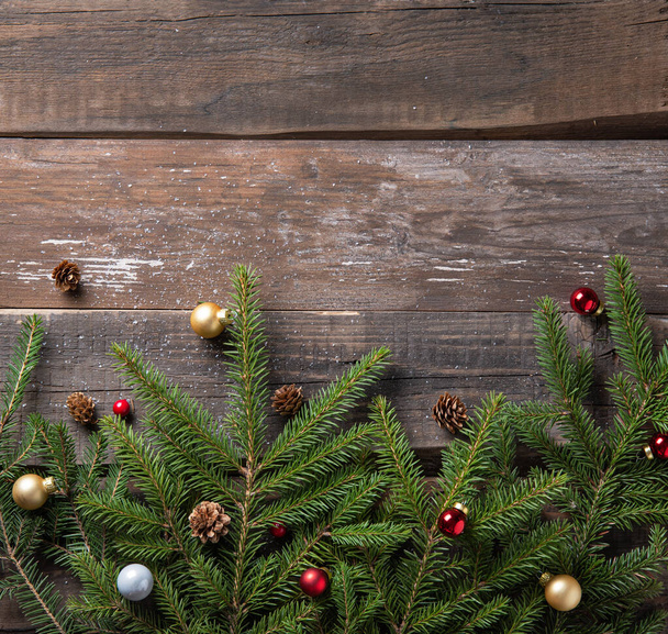 Noel arkaplanı süslemeler ve ladin dallarıyla eski, karanlık ahşap masada. Üst görünüm ve kopyalama alanı - Fotoğraf, Görsel