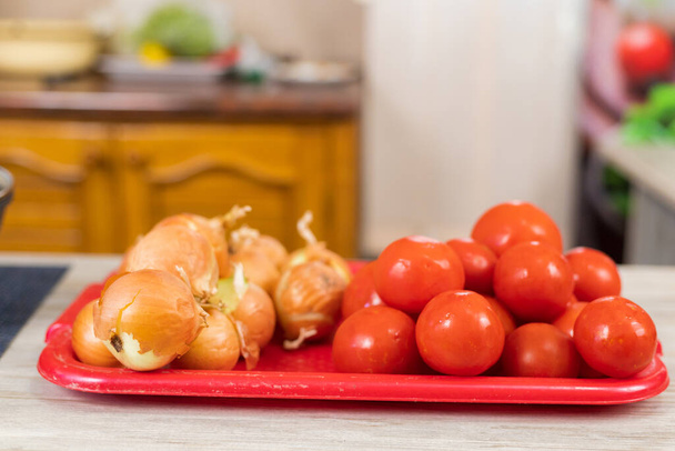 Zwiebeln und Tomaten. Kulinarischer Hintergrund mit selektivem Fokus und verschwommenem Hintergrund. - Foto, Bild