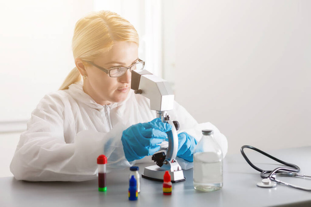 Femme travaillant avec un microscope en laboratoire - Photo, image