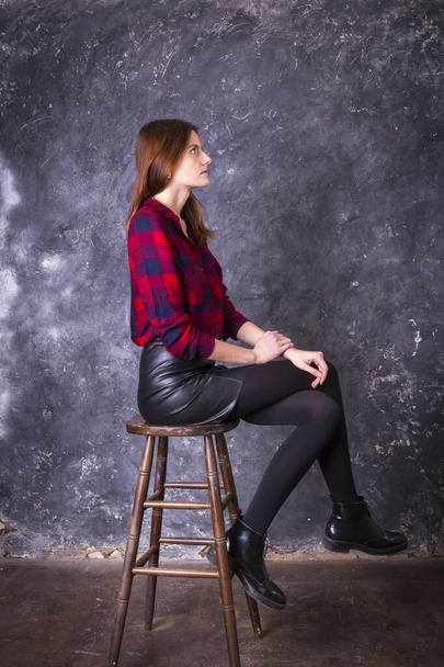 Studio portrait of young beautiful woman in a leather skirt - Fotografie, Obrázek