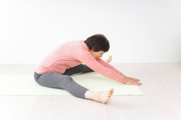 retrato de una mujer asiática mayor haciendo ejercicio de yoga  - Foto, imagen