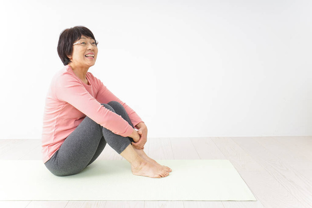 ritratto di una donna asiatica anziana che fa esercizio di yoga  - Foto, immagini
