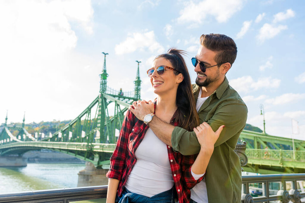A couple enjoying a sunny day in front of the liberty bridge in Budapest - Foto, Bild