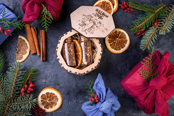 Uudenvuodenaatto glögille puulaatikossa. Tuoksuvia mausteita, appelsiininkuoria, kanelipuikkoja, badyania. Uuden vuoden lahja - Valokuva, kuva