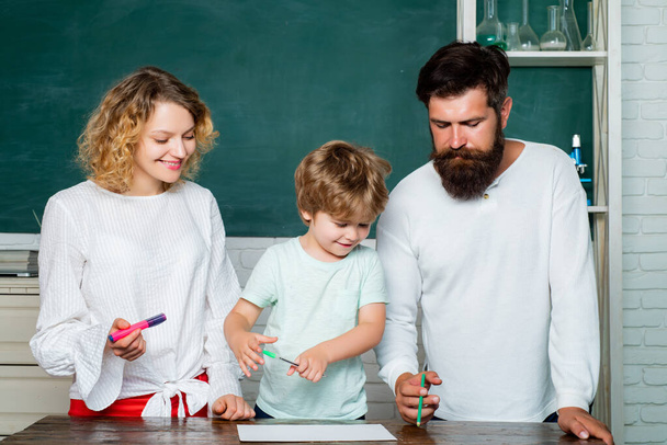 Learning and education concept. Young happy family schooling math together. Cute pupil and his father and mother making schooling work. - Fotoğraf, Görsel