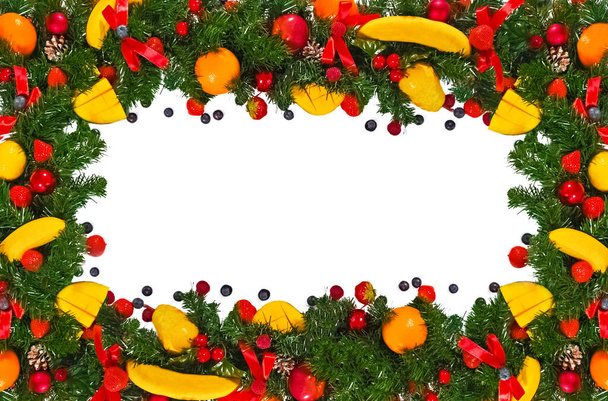 Christmas creative fun frame made of fir branches decorated with fruits, berries and bows, isolated on a white background.flat lay, top view.Mockup, copy space.The concept of a new year - Фото, зображення