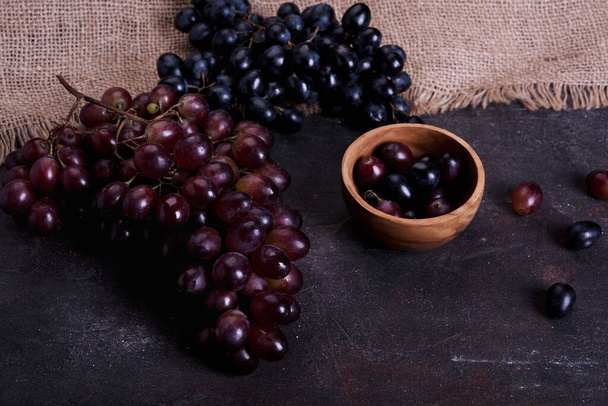 Ramas de uvas rojas y moradas sobre fondo rústico - Foto, imagen