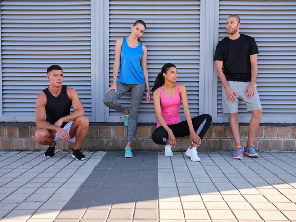 Young multiracial friends in sportswear standing near wall - Fotografie, Obrázek
