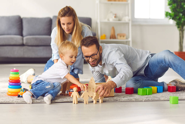 Happy family playing with toys on floor of their living-room, enjoying quality time at home - Foto, immagini