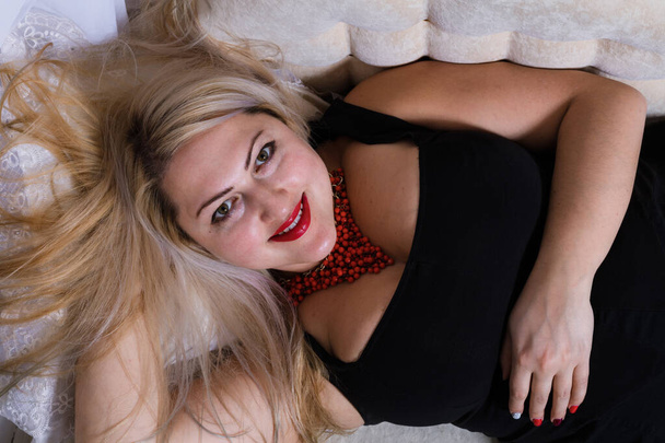 Attractive plump woman laying on sofa view from top studio portrait. - 写真・画像