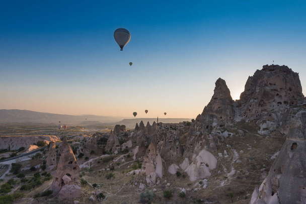 Burg und Stadt Uchisar, Heißluftballons im Sonnenaufgang, Kappadokien, Türkei - Foto, Bild