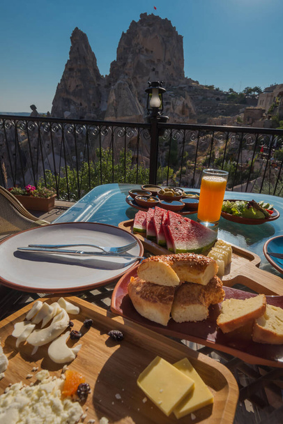 Tradycyjne tureckie śniadanie z widokiem na zamek Uchisar, Goreme, Kapadocja, Turcja. - Zdjęcie, obraz