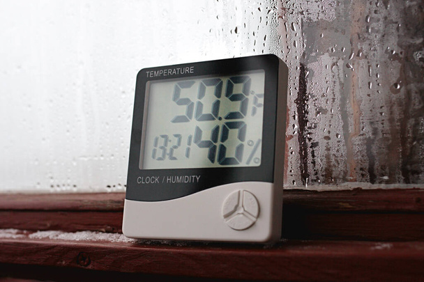El indicador de humedad se indica en el higrómetro del dispositivo. Una imagen de dispositivo electrónico para comprobar la temperatura y la humedad en el área cerrada - Foto, Imagen