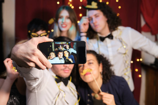 Ystävien ryhmä pitää hauskaa ja ottaa selfie joulujuhlissa. Joulujuhla. - Valokuva, kuva