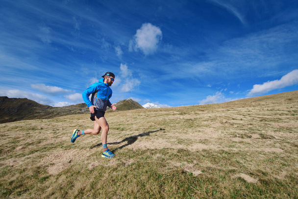 Αθλητικός άνθρωπος τρέχει σε μεγάλα ορεινά λιβάδια - Φωτογραφία, εικόνα