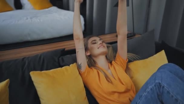 mujer tatuada lanzando sombrero de paja en el aire y sentado en el sofá - Metraje, vídeo