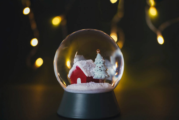 Κρυστάλλινη μπάλα με χιόνι με φώτα φόντου. Αντιγραφή χώρου. Χριστουγεννιάτικη ιδέα. - Φωτογραφία, εικόνα
