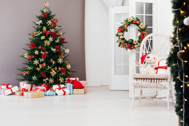 Pino árbol de Navidad con regalos de año nuevo vacaciones decoración roja fondo gris - Foto, Imagen
