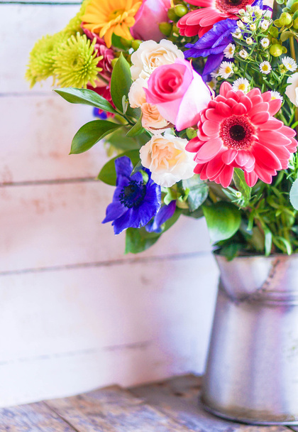 Colorful bouquet of spring flowers in vintage vase on rustic wooden background - Foto, Imagem