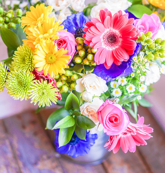 Colorful bouquet of spring flowers in vintage vase on rustic wooden background - Foto, afbeelding