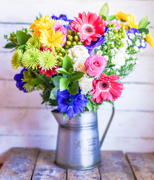 Colorful bouquet of spring flowers in vintage vase on rustic wooden background - Foto, Imagen