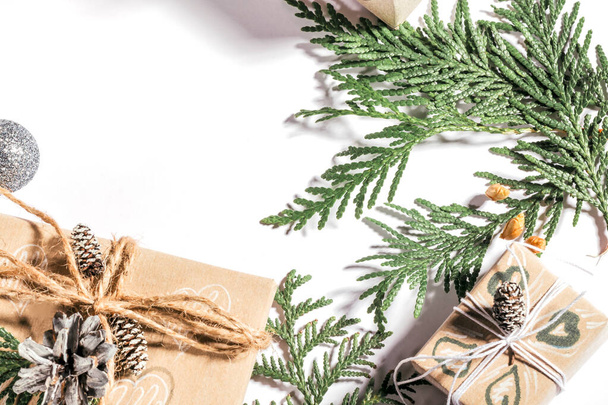 Fond de Noël avec des boîtes-cadeaux artisanales, des pinces de corde et des décorations avec des cônes de pin et des brindilles blanches. Préparation pour les vacances, - Photo, image