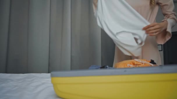 vista parcial de la mujer joven desempacando ropa en el hotel - Metraje, vídeo