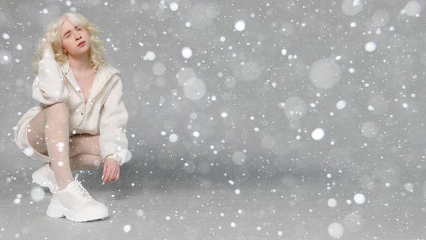 snow, winter, christmas, people, beauty concept - beautiful albino girl with white skin, natural lips and white curly hair wearing stylish white sweater,copy space, beauty. 16:9 panoramic format. - Photo, image