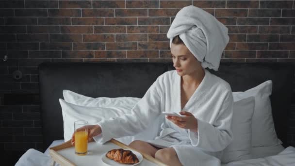 młoda kobieta w ręczniku robi zdjęcie śniadania na tacy w hotelu  - Materiał filmowy, wideo