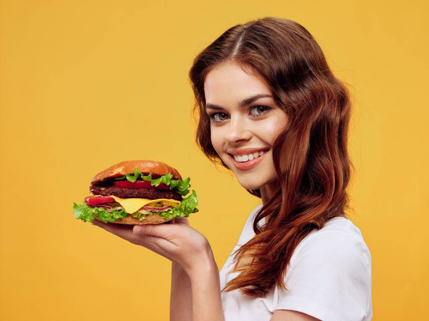 Vrouw met hamburger handen fast food restaurant voedsel dieet Gourmet  - Foto, afbeelding