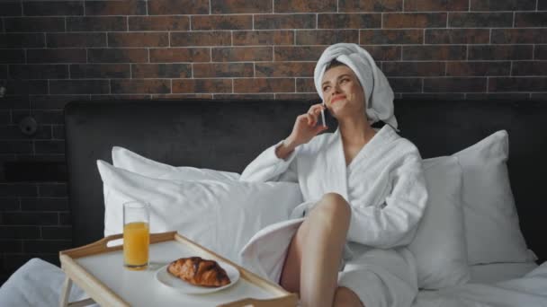 donna allegra che parla sullo smartphone vicino alla colazione in hotel  - Filmati, video