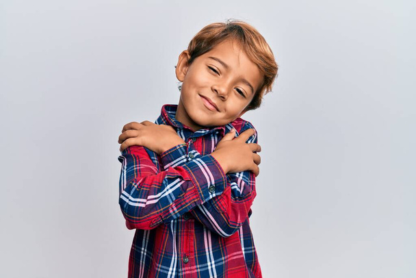 Adorable enfant latin portant des vêtements décontractés s'embrassant heureux et positif, souriant confiant. amour de soi et soins de soi  - Photo, image