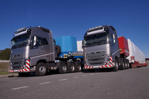 Dois camiões com semi-reboques especiais para o transporte de cargas de grandes dimensões. Carga de grandes dimensões ou comboio excepcional.  - Foto, Imagem