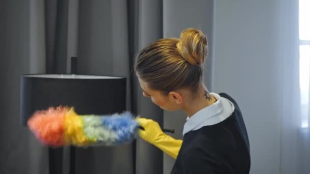 tatuado empregada doméstica limpeza poeira com escova no quarto de hotel - Filmagem, Vídeo