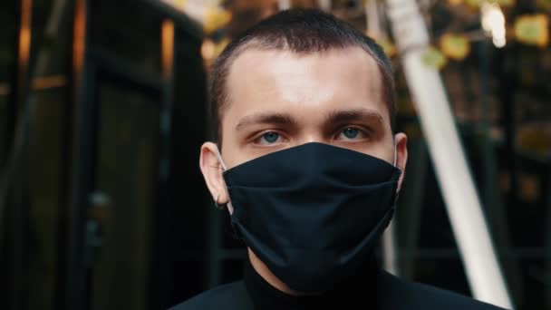Hombre retrato usando máscara facial protectora mira a la cámara COVID-19 coronavirus infección pandemia enfermedad virus masculino turismo epidemia aire salud enfermedad cámara lenta - Imágenes, Vídeo