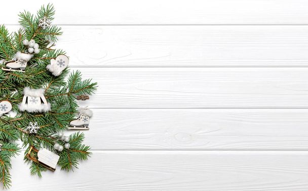 Сосновые ветви и деревянные украшения на белом фоне. Шаблон новогоднего плаката, пространство для копирования - Фото, изображение