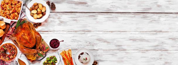 伝統的なクリスマスの七面鳥の夕食。素朴な白い木のバナーの背景にトップビューのコーナーの境界線。トルコ、ジャガイモと側面、詰め物、フルーツケーキと梅のプリン. - 写真・画像