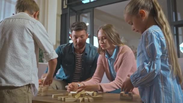 Pai falando enquanto joga blocos de madeira torre jogo com a família em casa - Filmagem, Vídeo