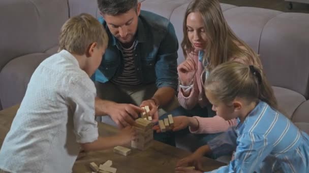 家のテーブルの上に家族の建物のブロック木の塔 - 映像、動画