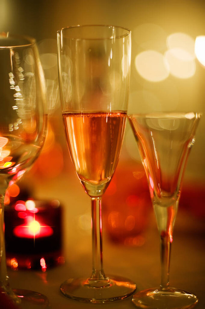 Vakantie champagne, kaarslicht en feestelijk gevoel, wazige bokeh achtergrond. - Foto, afbeelding
