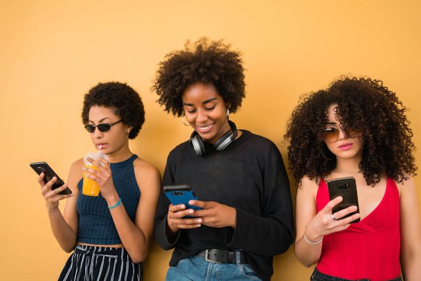 Three Afro friends using their mobile phone. - Valokuva, kuva