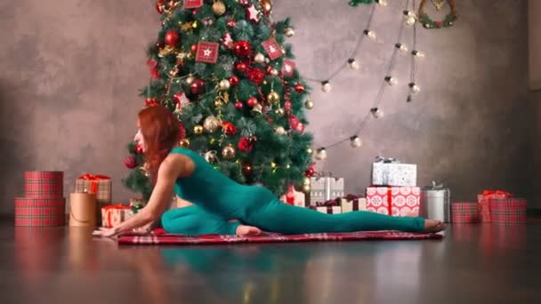 Zayıf kadın yoga yapıyor. Arka plan Noel ağacı. Yılbaşından sonra kilo kaybı - Video, Çekim