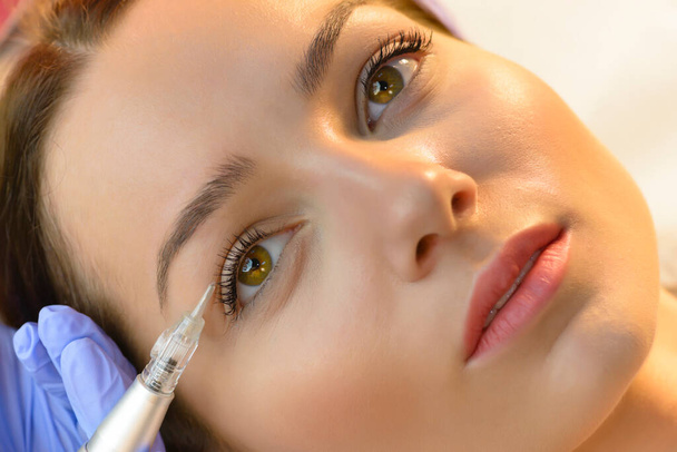 Attractive woman getting laser tattoo procedure at beauty salon - Foto, immagini