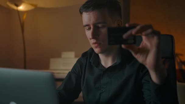 Jeune homme beau faire des achats en ligne avec carte de crédit et ordinateur portable - Séquence, vidéo