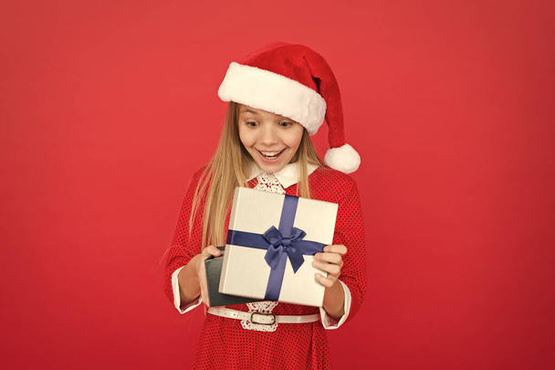 Winter holidays. Gift from Santa. Winter season. Fun time of year that you can easily tackle in a fun and organized manner. Little girl with christmas gift. Shopping concept. Winter tradition - Photo, image