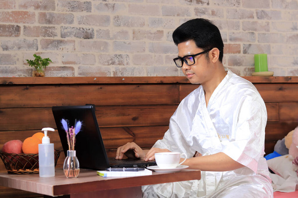Работа дома, коворкинг, азиатский человек, сидящий дома за ноутбуками и компьютерами, люди в карантине - Фото, изображение