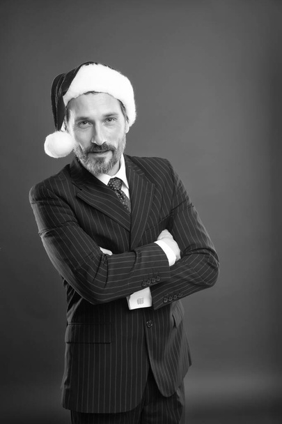 Businessman celebrate Christmas. Starting business that revolves around Christmas season. Business corporate. Event planner specializing. Christmas party concept. Man with beard formal suit Santa hat - 写真・画像