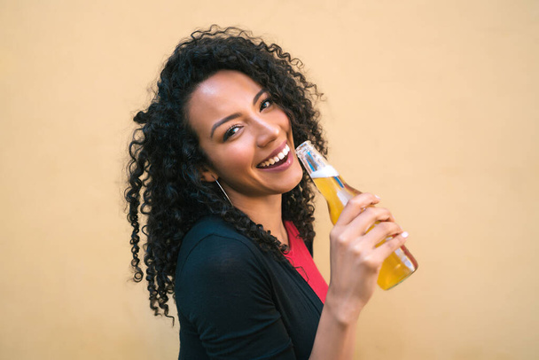 Young afro woman drinking beer. - Φωτογραφία, εικόνα