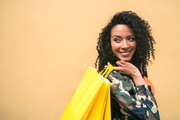 Afro american latin woman holding shopping bags. - Foto, afbeelding