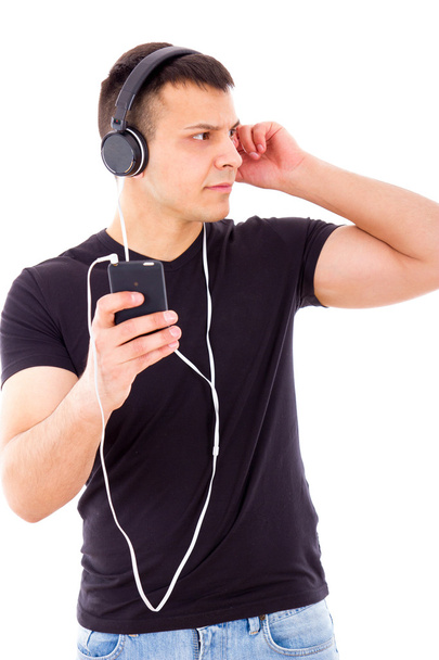 stunned curious man listening something on mobile over headphone - Foto, imagen
